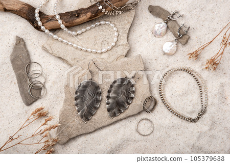 Beautiful Silver and Pearl Jewelry on white stones and sand. Various jewelry - bracelets, necklaces and rings. Beautiful Silver and Pearl Jewelry on white stones and sand. Various jewelry - bracelets, necklaces and rings. 105379688