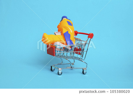 Water gun in shopping basket on blue background 105380020