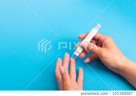 The lancet device pierces the finger closeup 105380087