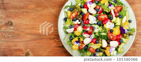Summer salad with edible flowers,space for text. Summer salad with edible flowers,space for text. 105380366