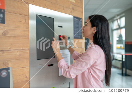 Woman buying coffee from automatic vending machine. Woman buying coffee from automatic vending machine. 105380779
