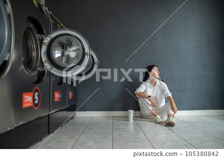 Woman waiting in public laundry room. Woman waiting in public laundry room. 105380842