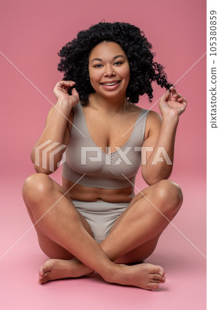 Smiling contented woman on a pink background 105380859