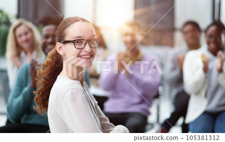 Smiling businesswoman in glasses looking at camera at a seminar 105381312