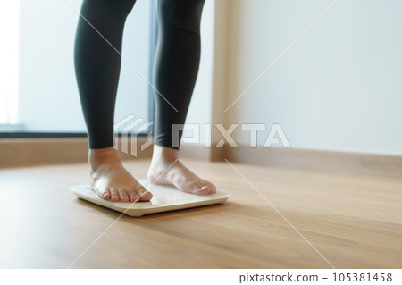 Lose weight. Fat diet and scale feet standing on electronic scales for weight control. Measurement instrument in kilogram for diet. Lose weight. Fat diet and scale feet standing on electronic scales for weight control. Measurement instrument in kilogram for diet. 105381458