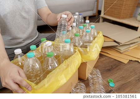 Home recycle eco green zero concept Man throwing empty plastic bottle in recycling bin with yellow garbage bags at home 105381561