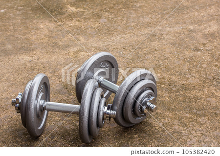 Dumbbells on cement floor Dumbbells on cement floor 105382420