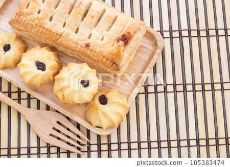 Pineapple pie and cookies in wooden plate on wooden table Pineapple pie and cookies in wooden plate on wooden table 105383474
