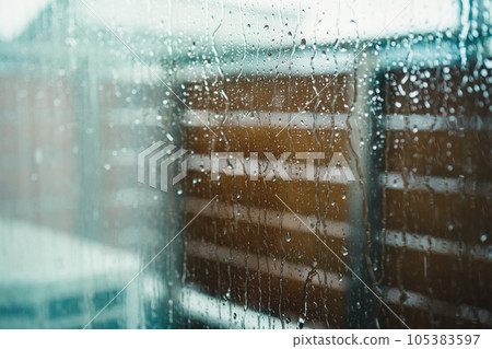 被雨淋濕的房子的窗戶玻璃 105383597