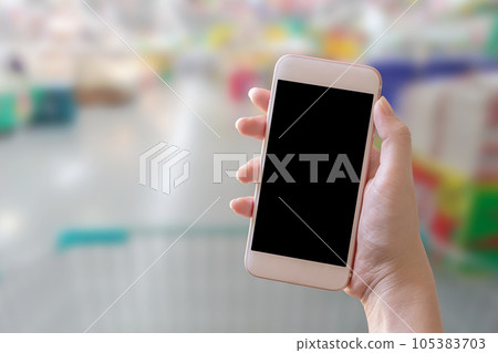 Hand holding smart phone with blur background 105383703