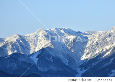Mountain with snow. Alps. Switzerland. Panoramic view of the Snowy Alps and blue sky around the Titlis mountain. French Alps. Alpine mountains. Descent peaks on the Austrian snow slopes. ski slopes. Mountain with snow. Alps. Switzerland. Panoramic view of the Snowy Alps and blue sky around the Titlis mountain. French Alps. Alpine mountains. Descent peaks on the Austrian snow slopes. ski slopes. 105385534