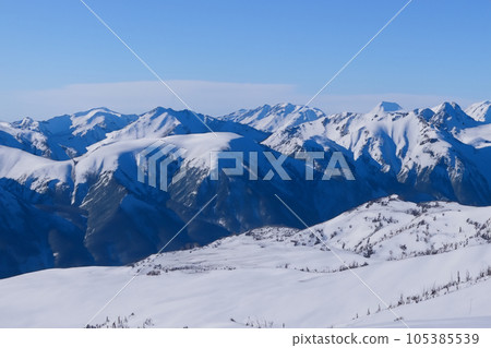 Mountain with snow. Alps. Switzerland. Panoramic view of the Snowy Alps and blue sky around the Titlis mountain. French Alps. Alpine mountains. Descent peaks on the Austrian snow slopes. ski slopes. Mountain with snow. Alps. Switzerland. Panoramic view of the Snowy Alps and blue sky around the Titlis mountain. French Alps. Alpine mountains. Descent peaks on the Austrian snow slopes. ski slopes. 105385539