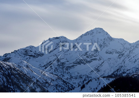 Mountain with snow. Alps. Switzerland. Panoramic view of the Snowy Alps and blue sky around the Titlis mountain. French Alps. Alpine mountains. Descent peaks on the Austrian snow slopes. ski slopes. Mountain with snow. Alps. Switzerland. Panoramic view of the Snowy Alps and blue sky around the Titlis mountain. French Alps. Alpine mountains. Descent peaks on the Austrian snow slopes. ski slopes. 105385541