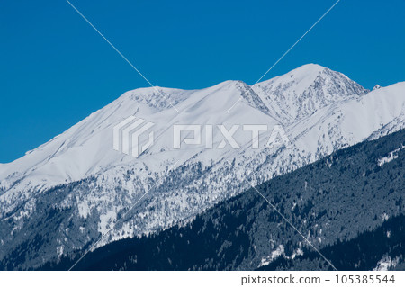 Mountain with snow. Alps. Switzerland. Panoramic view of the Snowy Alps and blue sky around the Titlis mountain. French Alps. Alpine mountains. Descent peaks on the Austrian snow slopes. ski slopes. Mountain with snow. Alps. Switzerland. Panoramic view of the Snowy Alps and blue sky around the Titlis mountain. French Alps. Alpine mountains. Descent peaks on the Austrian snow slopes. ski slopes. 105385544