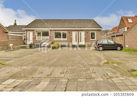 a house with a car parked in the driveway and two cars parked on either side of the road, all facing towards each other 105385609