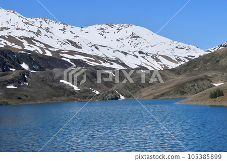 Mountain with snow and lake. Picturesque winter sunset in Swiss Alps, Grindelwald. The beauty of nature as a conceptual background. Small rivers and coniferous trees reflected in a calm alpine lake. 105385899