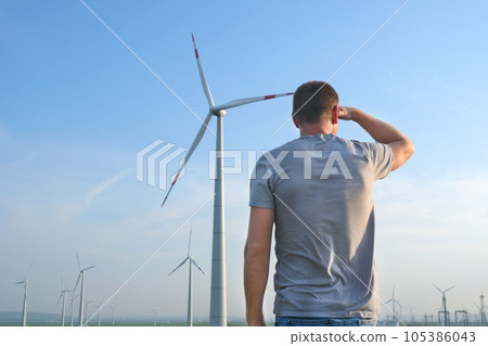 The man stands with his back and looks at the wind The man stands with his back and looks at the wind 105386043