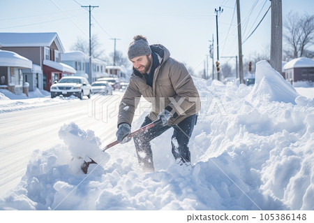 Snow removal. Man clearing snow by shovel after snowfall. Outdoors. 105386148