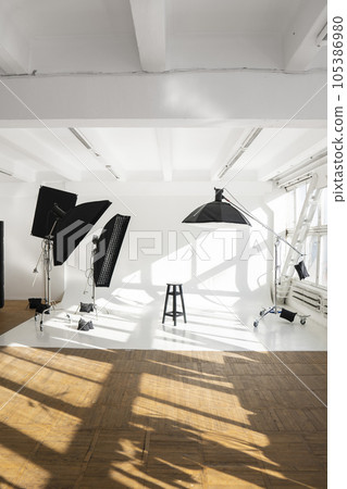 Empty photo studio with white big huge cyclorama and professional equipment, ligts, stands and soft boxes. 105386980