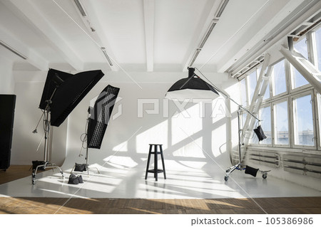 White big huge cyclorama in modern professional photo studio with a professional equipment, ligts, stands and soft boxes. 105386986