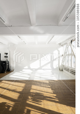 Clean big white cyclorama in a photo studio with a sunlight and shadows from a huge window. Plain wall empty photo studio. Clean big white cyclorama in a photo studio with a sunlight and shadows from a huge window. Plain wall empty photo studio. 105386988