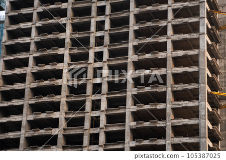 Construction of monolithic building for residential house, office or apartment. Construction site, high-rise, facade of multi-story building. 105387025