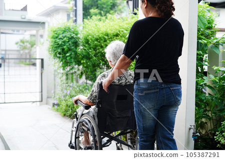 Caregiver help Asian elderly woman disability patient sitting on wheelchair in hospital, medical concept. Caregiver help Asian elderly woman disability patient sitting on wheelchair in hospital, medical concept. 105387291