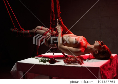 Pleaser during evening dinner with topless female tied with ropes Pleaser during evening dinner with topless female tied with ropes 105387763