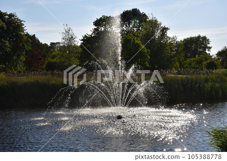 Den Helder, Netherlands. July 9, 2023. A fountain with backlight i a park in Den Helder. Den Helder, Netherlands. July 9, 2023. A fountain with backlight i a park in Den Helder. 105388778