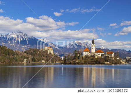 Bled lake with Bled catle, church and winter Julian Alps at background 105389272