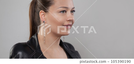 Nice fashion model wearing long lines jewelry earring with diamonds on grey banner background Nice fashion model wearing long lines jewelry earring with diamonds on grey banner background 105390190