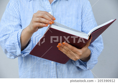 Young woman holding book in her hands , with space for text Young woman holding book in her hands , with space for text 105390912