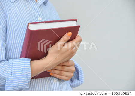 Young woman holding book in her hands , with space for text Young woman holding book in her hands , with space for text 105390924