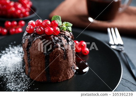 Delicious warm chocolate lava cake with mint and berries on table, closeup Delicious warm chocolate lava cake with mint and berries on table, closeup 105391239