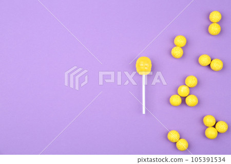 Different lemon candies on purple background, top view. Space for text Different lemon candies on purple background, top view. Space for text 105391534