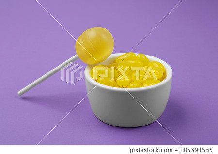 Different lemon flavored candies on purple background 105391535