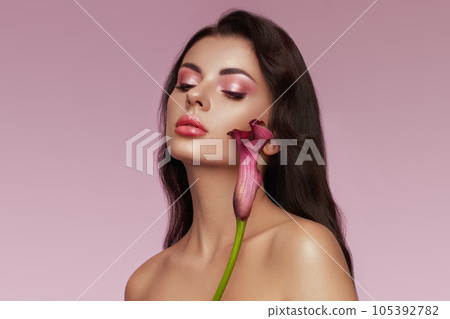 Beautiful young woman with a calla flower Beautiful young woman with a calla flower 105392782