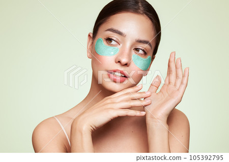 Young woman with cosmetic patches on her eyes Young woman with cosmetic patches on her eyes 105392795