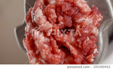 Macro shot of mincing meat in grinder. Cooking at home, kitchen appliance, healthy nutrition, hamburger ingredients. 105393452