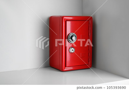 Red steel safe with mechanical combination lock on shelf 105393690