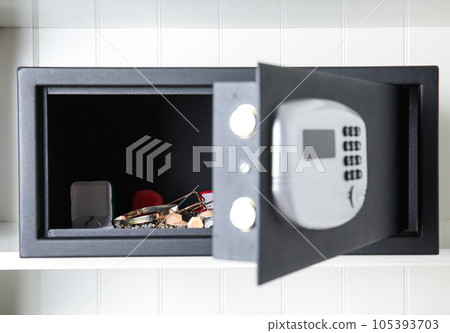 Open black steel safe with money and jewelry on shelf 105393703