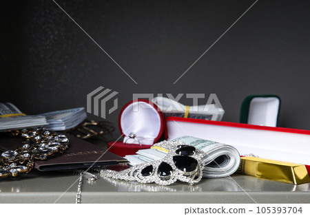 Open steel safe with money, gold bars and jewelry, closeup Open steel safe with money, gold bars and jewelry, closeup 105393704