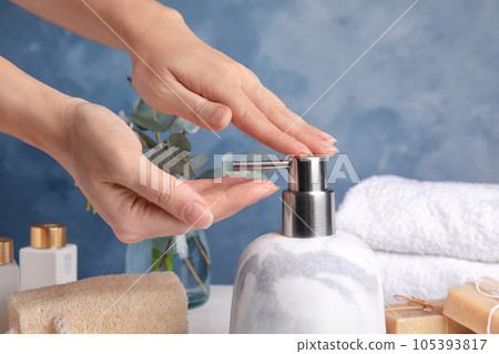 Woman using soap dispenser indoors, closeup view Woman using soap dispenser indoors, closeup view 105393817