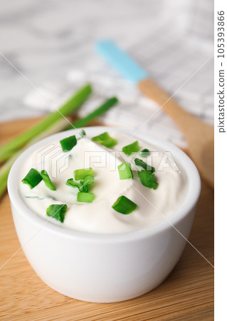 Fresh sour cream with onion on wooden board, closeup Fresh sour cream with onion on wooden board, closeup 105393866