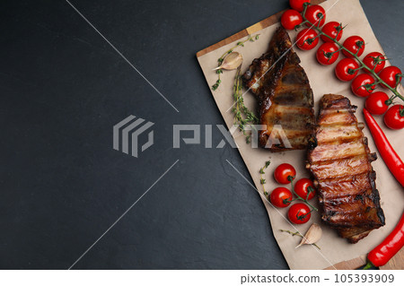 Tasty grilled ribs on black table, flat lay. Space for text 105393909