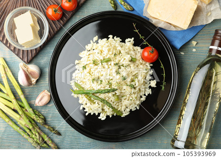 Delicious risotto with asparagus served on blue wooden table, flat lay 105393969