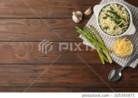 Delicious risotto with asparagus served on wooden table, flat lay. Space for text Delicious risotto with asparagus served on wooden table, flat lay. Space for text 105393975