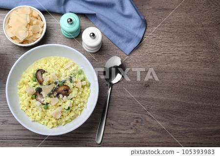 Delicious risotto with cheese and mushrooms on wooden table, flat lay. Space for text Delicious risotto with cheese and mushrooms on wooden table, flat lay. Space for text 105393983