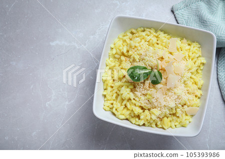 Delicious risotto with cheese on grey marble table, top view. Space for text 105393986