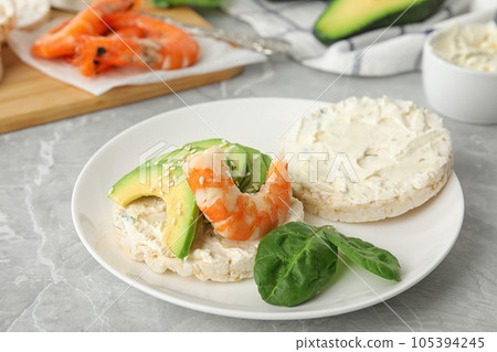 Puffed rice cake with shrimp and avocado on grey marble table 105394245